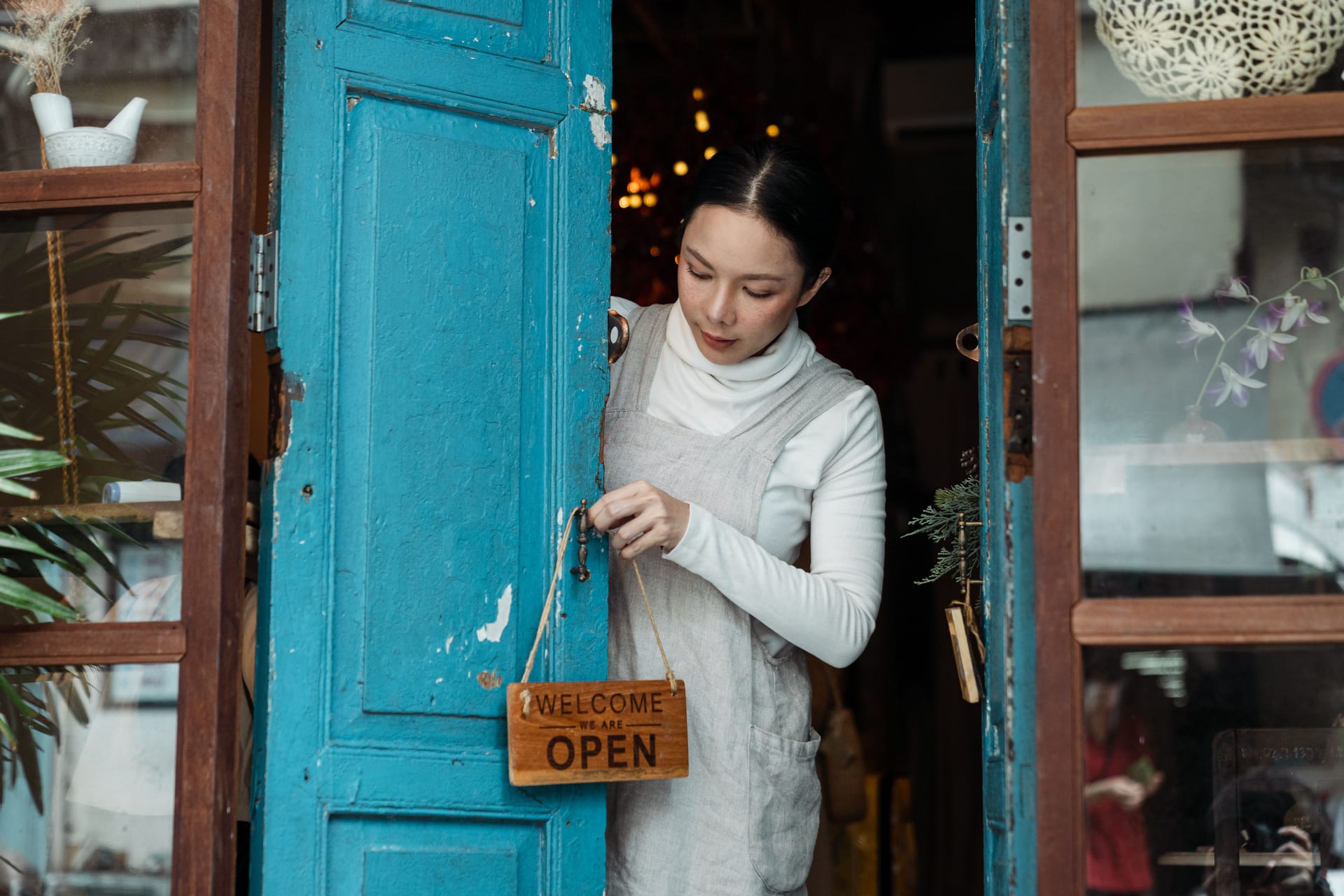 A small-business owner working at a tablet POS on a timber counter