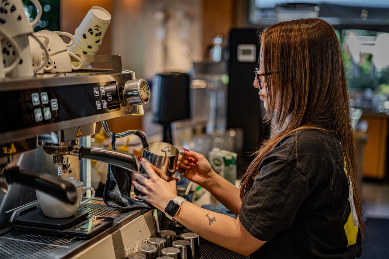 A barista pulling a shot at the espresso machine during the morning rush